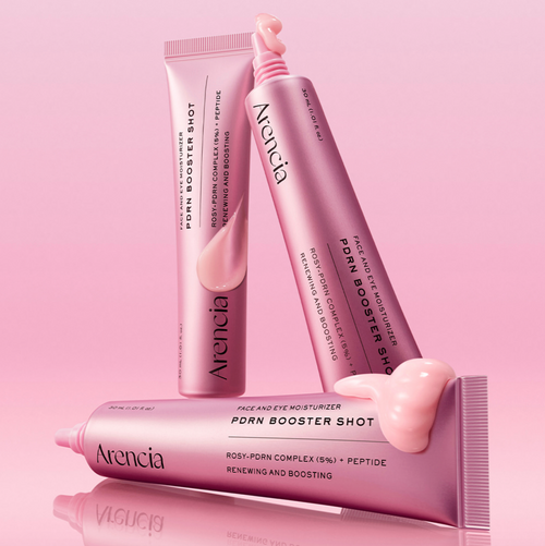 Tres tubos rosa metálico Arencia PDRN Booster Shot; uno horizontal con crema saliendo y otro abierto con boquilla, 30 ml visible, sobre fondo rosa brillante.